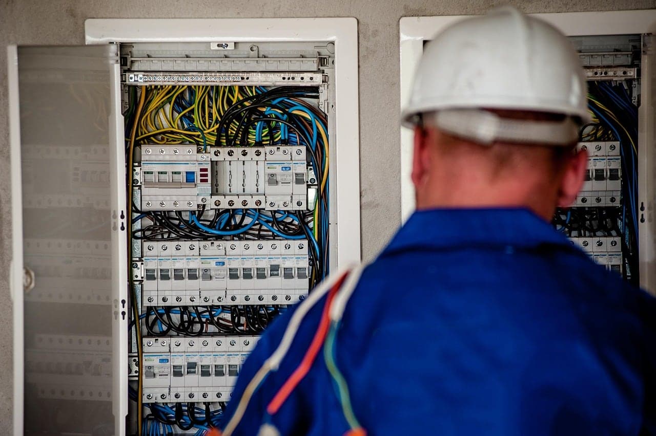 An electrician works on a distribution board