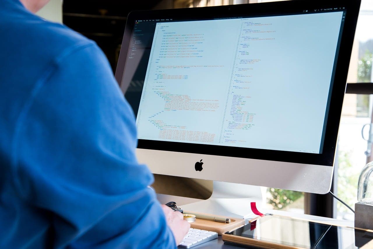 A developer writing code on a desktop computer