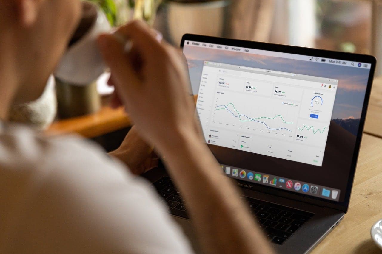 A laptop showing a live analytics dashboard on a wooden desk