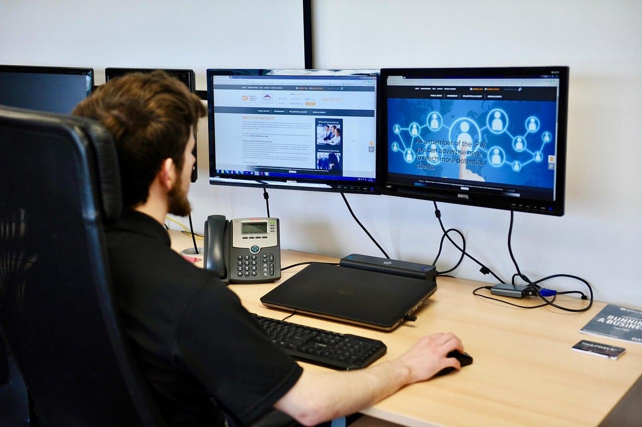 A developer at a desk with two monitors